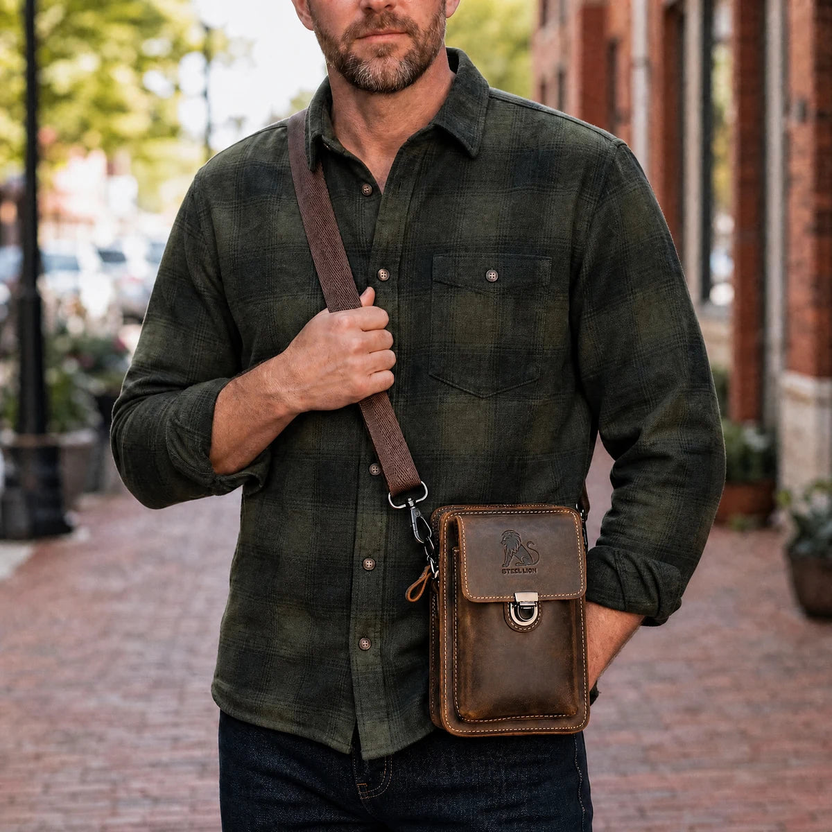 Man carrying the brown leather phone holster on a shoulder strap