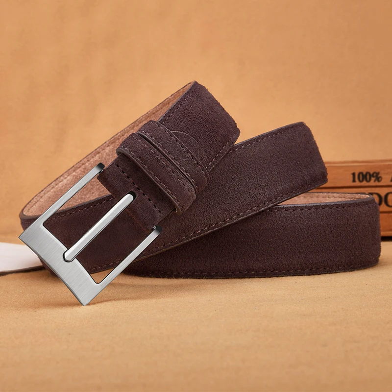 Brown suede belt with a silver buckle on a brown background