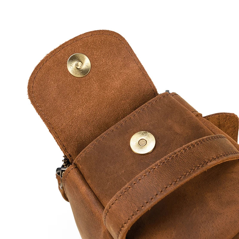 Close-up of a brown leather pouch with gold metal buttons on a white background