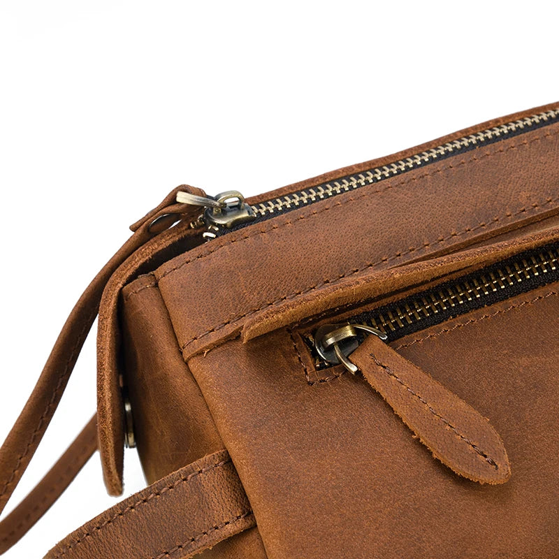 Close-up of a brown leather bag with zippers on a white background