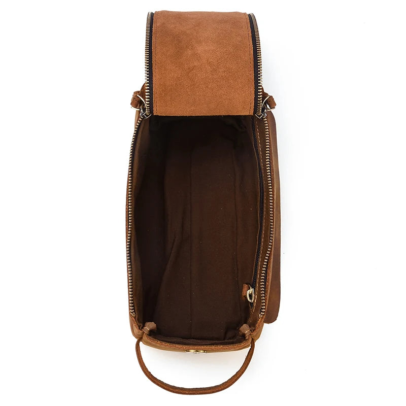 Brown leather bag with a strap on a white background