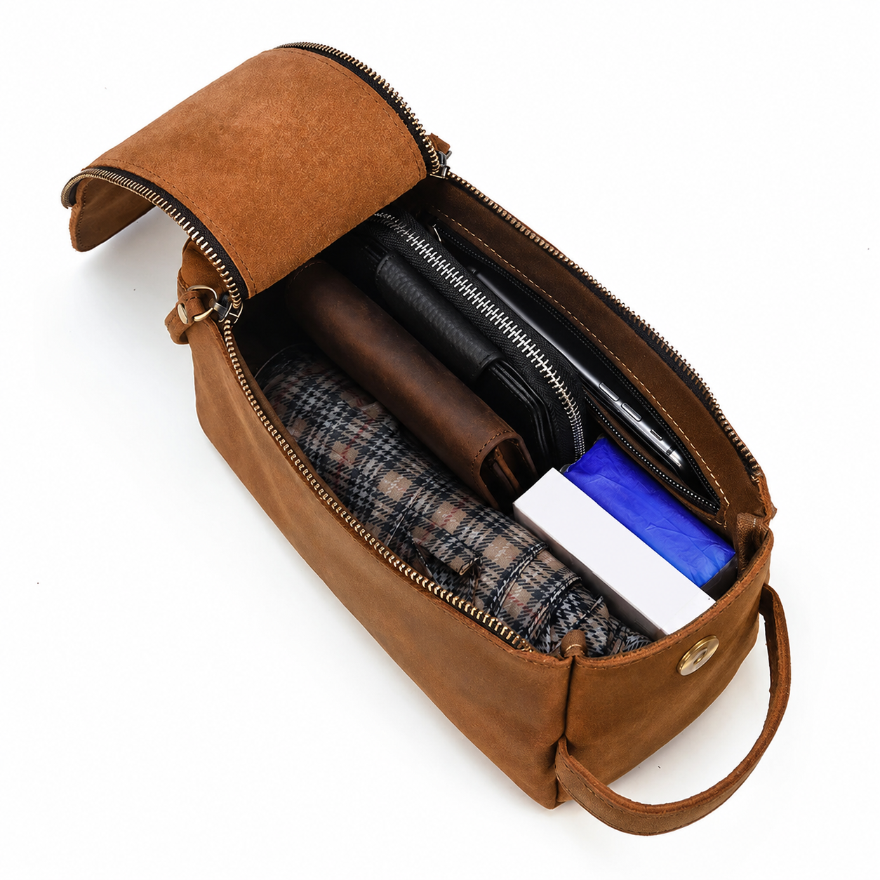 Brown leather bag with plaid lining and various items on a white background